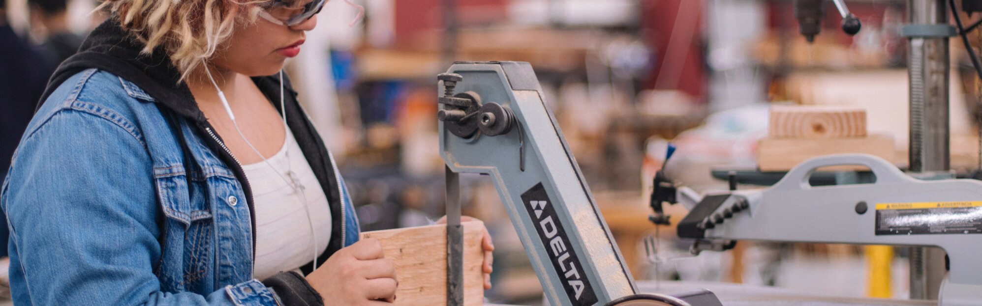 Auszubildende der Holztechnik arbeitet an einer Stichsäge. 