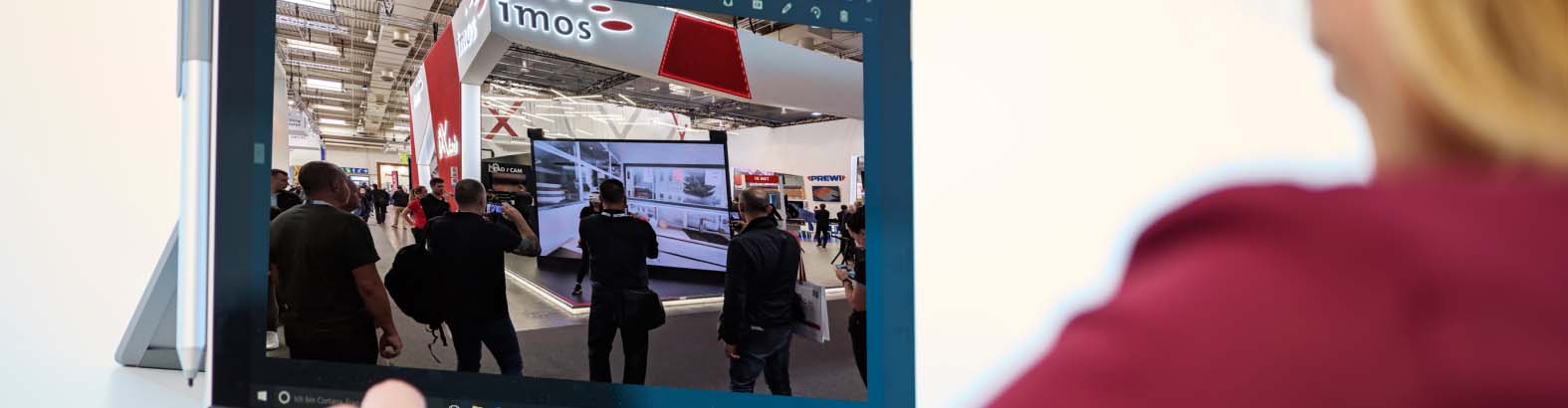 imos Messestand LIGNA 2017 auf Bildschirm mit Frau im Anschnitt